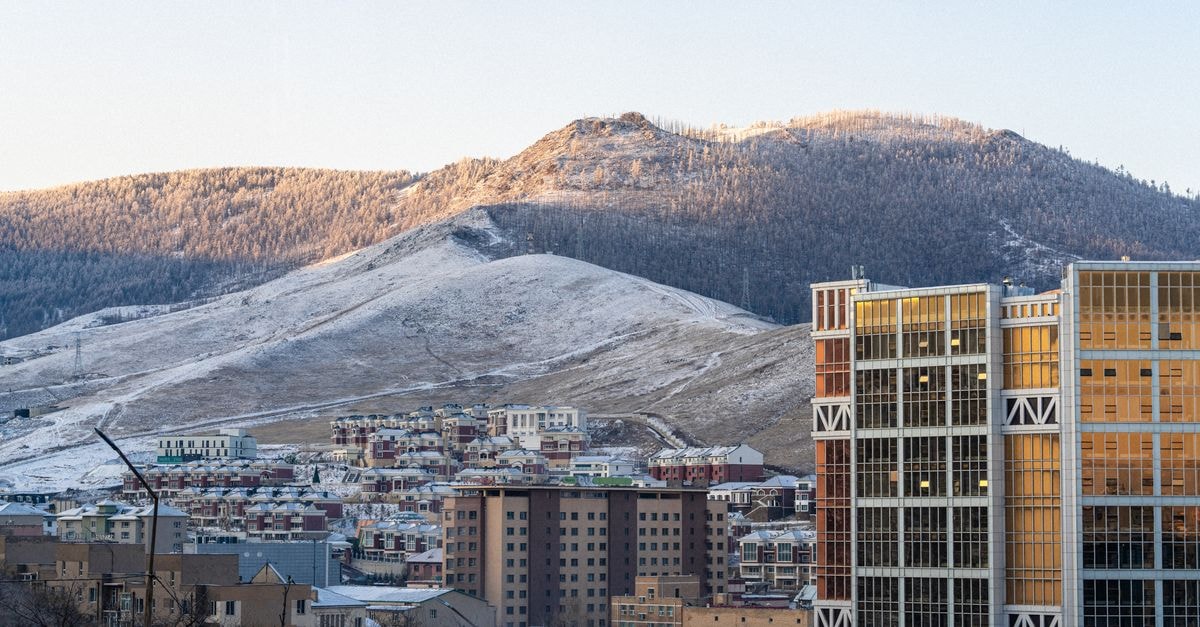 Taij Business Hotel in Ulaanbaatar: Central Stay on Peace Avenue Cityscape of Ulaanbaatar, Mongolia with mountains in the background during sunrise.