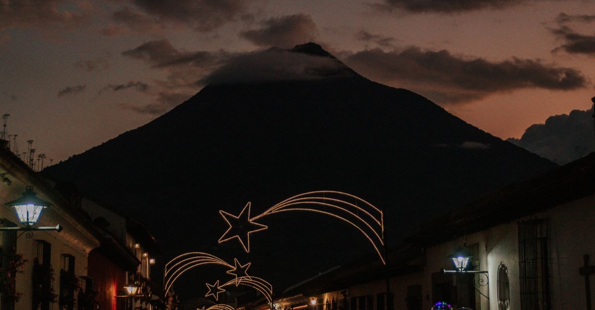 Hotel Posada Plácida Antigua in Antigua Guatemala: A Calle De Candelaria Corner Stay Beautiful Christmas decorations light up streets of Antigua Guatemala with the Agua Volcano in the background.