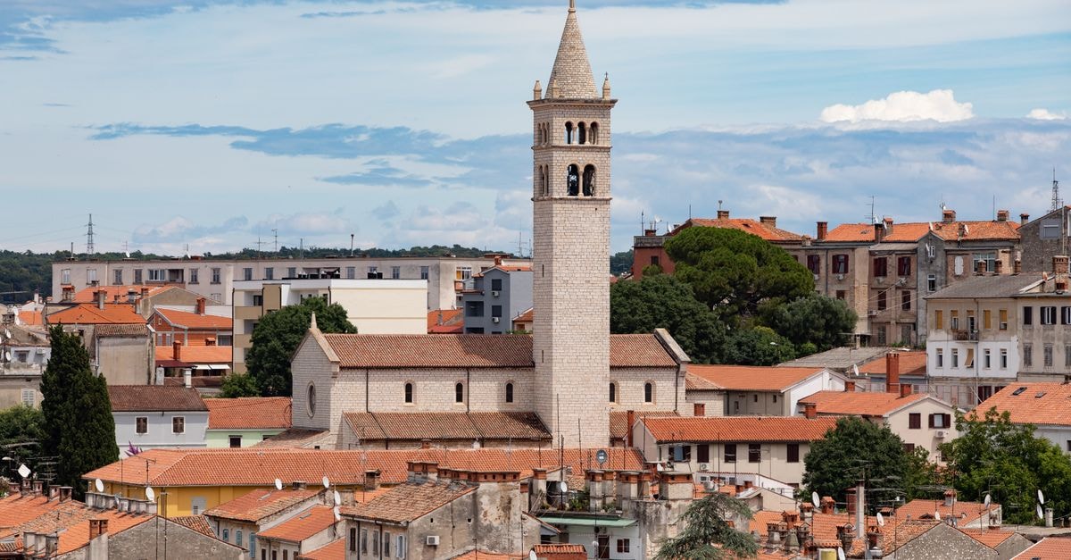 Hostel Antique in Pula: Roman-Era Steps from the Arena Aerial view of historic church tower amidst Pula, Croatia's cityscape on a sunny day.