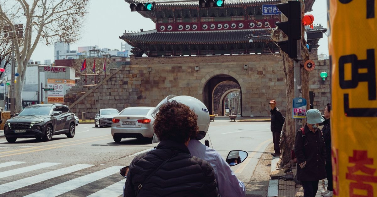 Suwon Travel Guide: Fortress Streets, Galleries and Local Flavors Vibrant street scene at Hwaseong Fortress in Suwon, South Korea with spring blooms and city life.