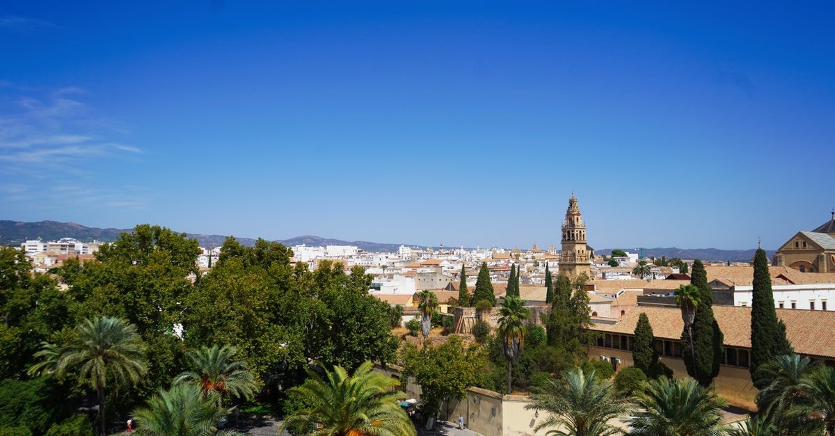 Eurostars Patios de Córdoba, Cordoba — Steps from the Mezquita Aerial view of Córdoba, Spain, featuring lush gardens and historic architecture under a clear blue sky.