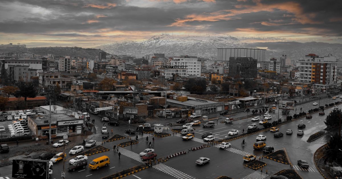 Azin Hotel in Gorgan: Seven Floors Overlooking Turkmen Plains Aerial view of Kabul city skyline with traffic at sunset, featuring mountains and urban architecture.