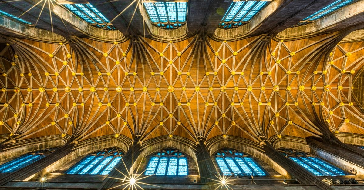 Coventry Travel Guide: Planning Tips, Costs and Things to Do Intricate Gothic cathedral ceiling with stained glass windows from a low angle.