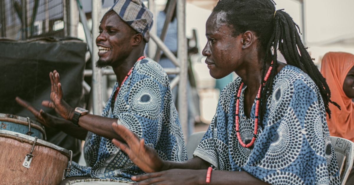 Traditional musicians performing at a cultural festival in Ilorin, Nigeria, showcasing vibrant African drums and attire.