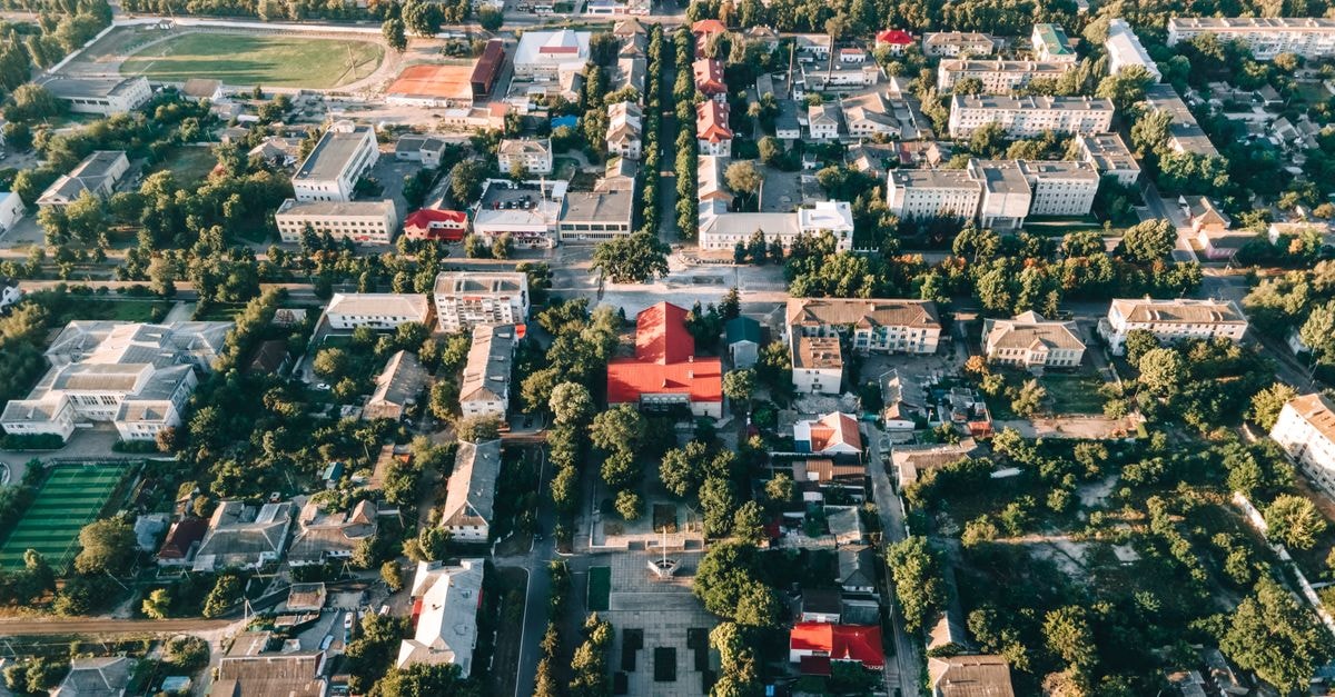 High-angle aerial view of a vibrant urban townscape with buildings and trees.