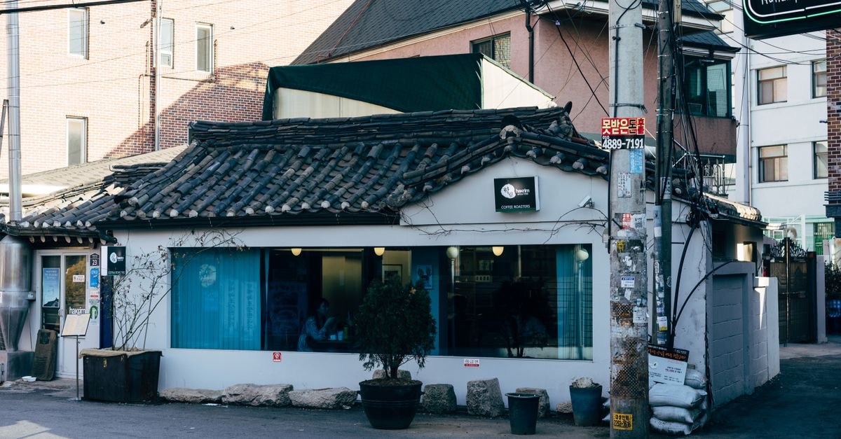 A charming traditional café with tiled roof in a Seoul street setting.