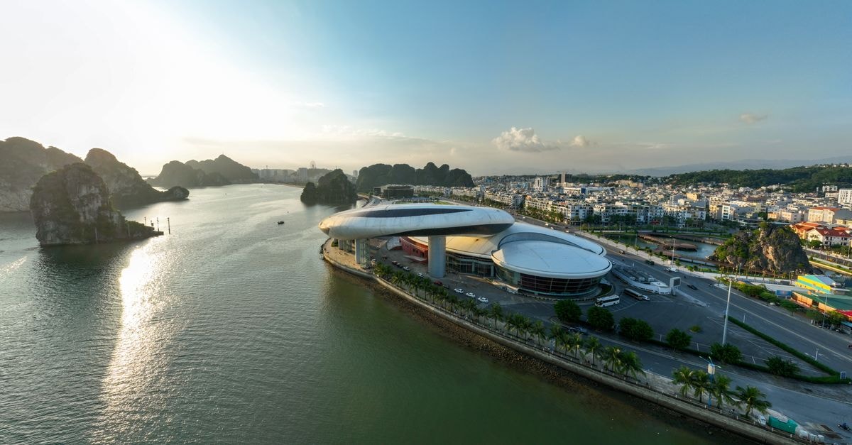 Wyndham Garden Legend Halong in Ha Long: Two Rooftop Pools Overlooking the Bay A stunning aerial view of modern architecture against the scenic Ha Long Bay at sunset in Vietnam.
