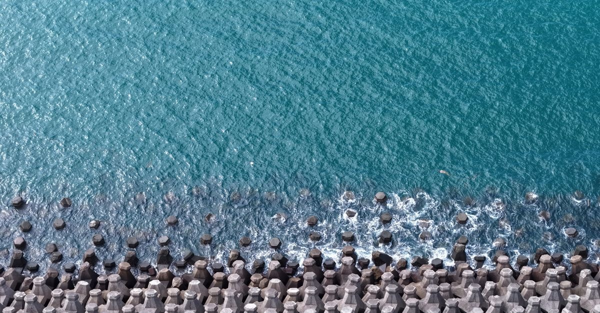 Keelung Travel Guide: Harbor City Sights, Bites and Easy Taipei Links A stunning aerial view of a hexagonal breakwater with vibrant blue ocean waves crashing against it.