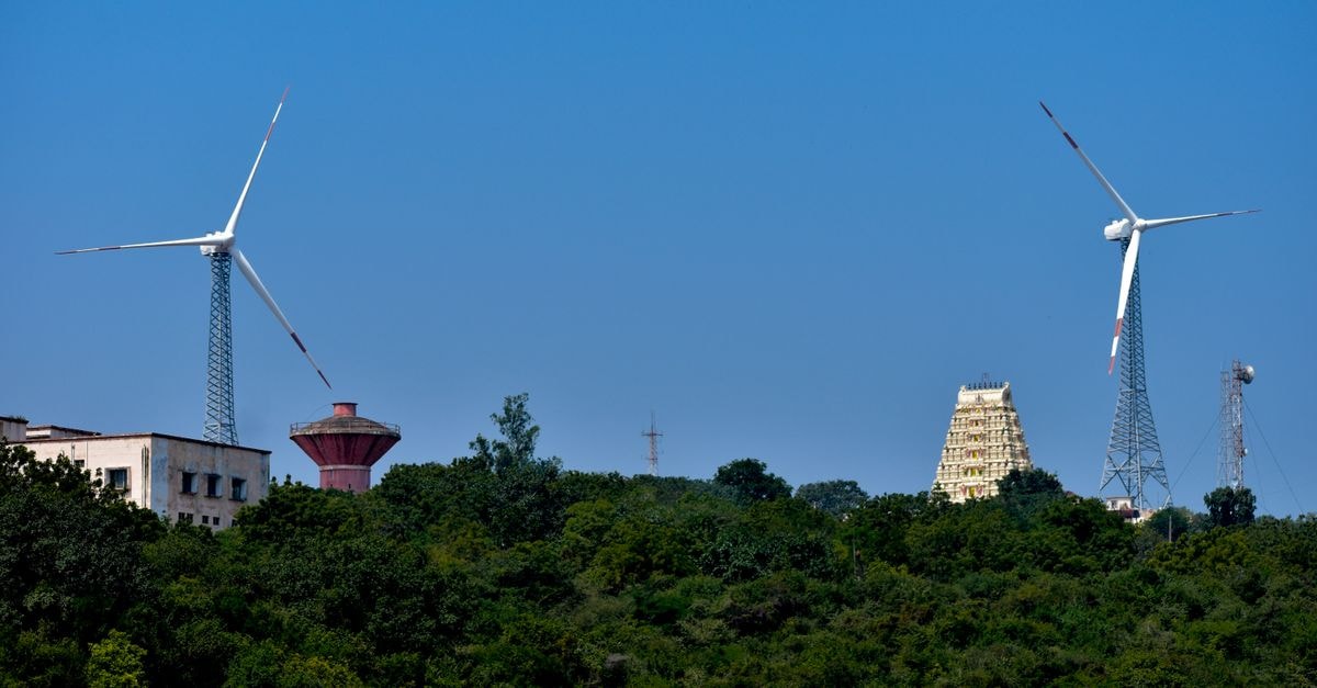 Hotel Presidents Inn in Nellore: a Trunk Road stay near VRC Centre Scenic view of wind turbines and ancient temple amidst lush greenery under clear blue skies in Nellore, India.