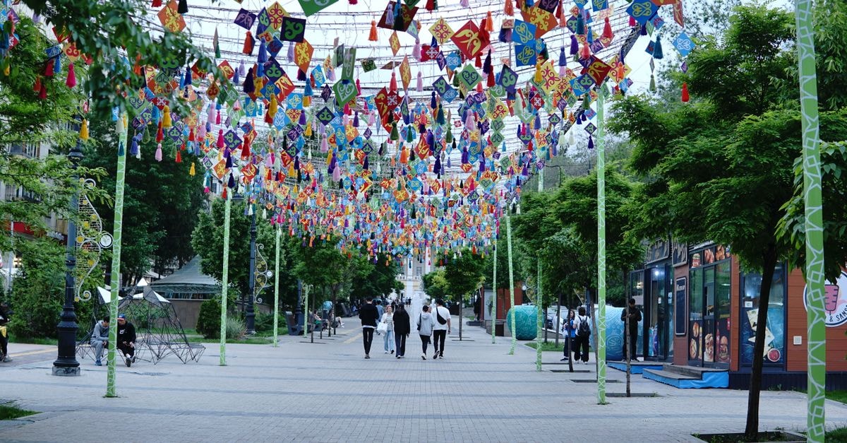 Vibrant street in Almaty with colorful decorations and people walking.