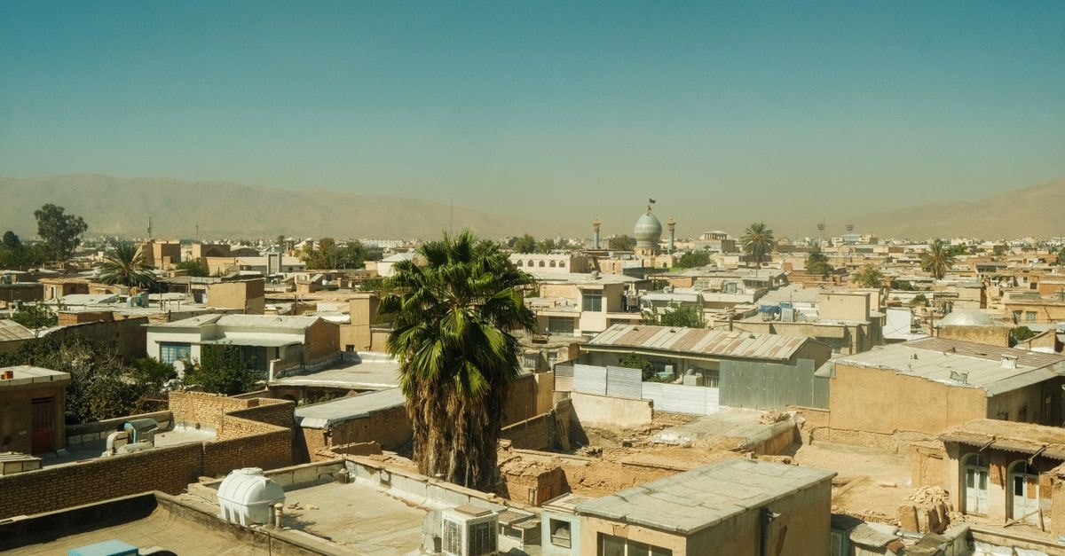 Central Hotel, Kabul — A Centrally Located Stay in the Capital A panoramic view of Shiraz's rooftops, featuring a prominent mosque under a clear blue sky.