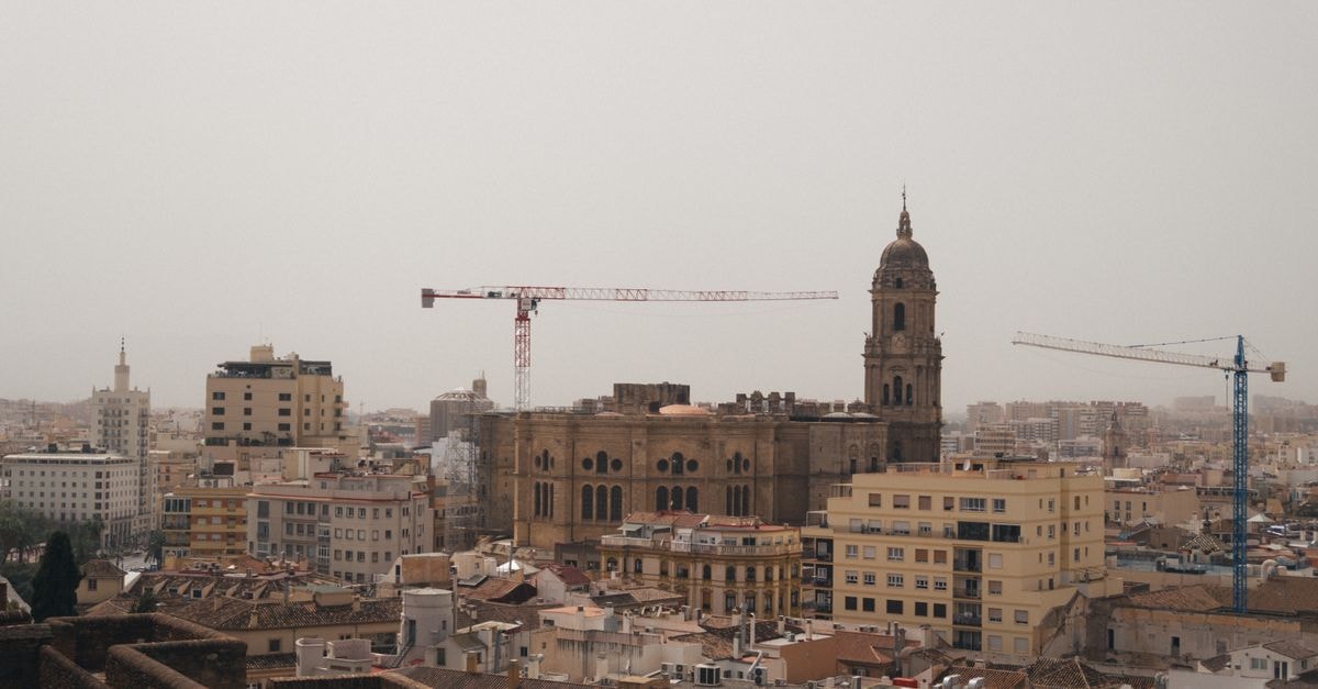 Mahadev Hotel, Muzaffarnagar — A 2009 Address on Muzzafarnagar-Mirapur Marg A stunning urban landscape featuring Malaga Cathedral amidst cranes and city buildings.