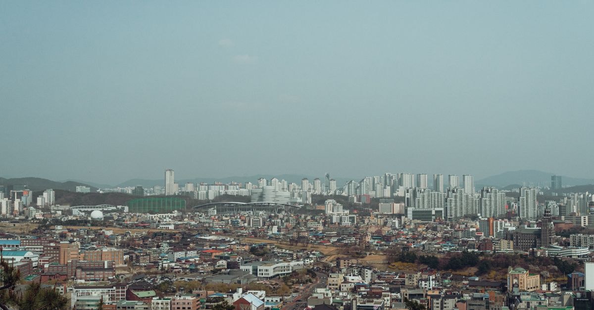 Empathy Guesthouse in Daegu: Warm Welcome Downtown A sweeping view of Seoul's urban landscape with a mix of modern skyscrapers and traditional architecture.