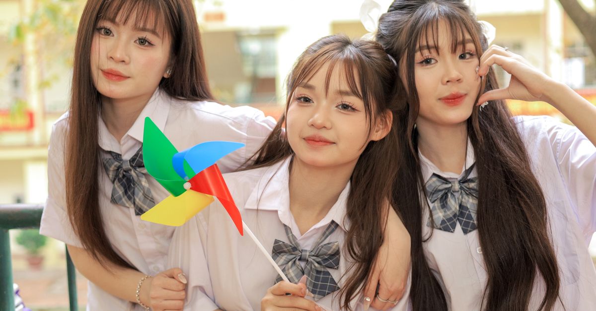 Hybe girl groups' 'Iconic By Mistake' surpasses 100 million Spotify streams in 41 days Three cheerful teenage girls in school uniforms with a colorful pinwheel enjoying a sunny day outdoors.