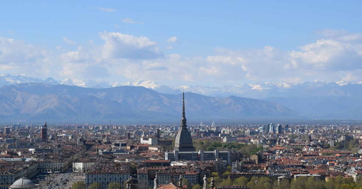 Stunning view of Turin cityscape with the Mole Antonelliana and Italian Alps in the distance.