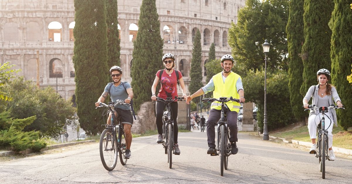 Things to Do in Rome in July 2026: A Heat-Smart Travel Guide Group of cyclists enjoying a summer bike tour near the iconic Colosseum in Rome.