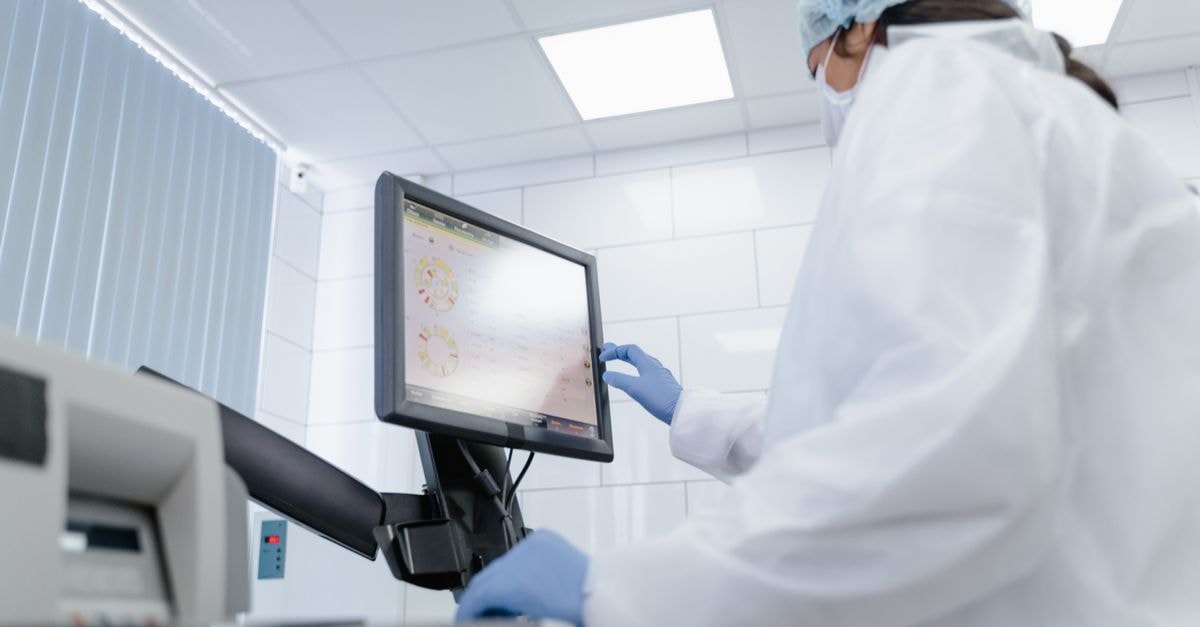BlackRock and Pzena Take New Positions in CVS Health as Institutional Ownership Holds at 80.66% Woman in lab coat using touchscreen monitor in a modern laboratory setting.