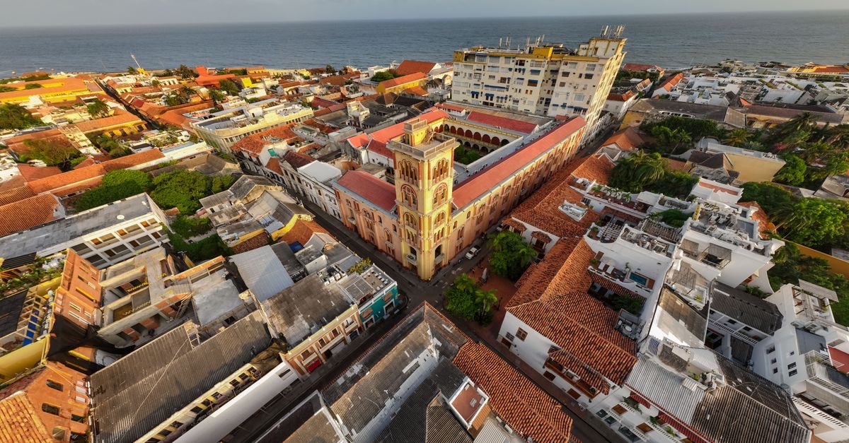 Hotel Ceibo Dorado in Portoviejo: A Comfy City Stay A stunning aerial shot of a coastal town with historic architecture and vibrant rooftops by the sea.