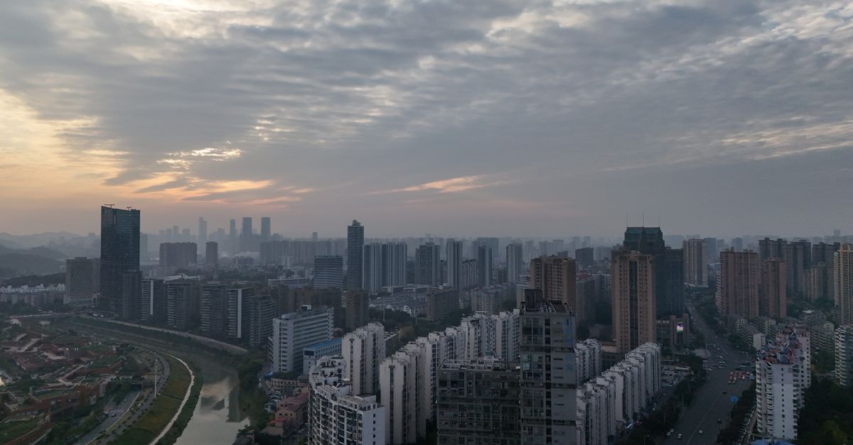 Aerial view of Changsha city skyline with dramatic clouds at dusk.