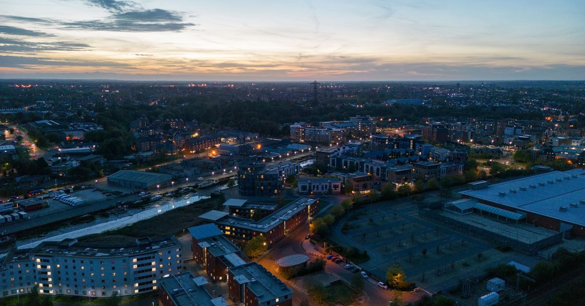 A stunning aerial view of the cityscape at dusk, showcasing illuminated buildings and a fading horizon.