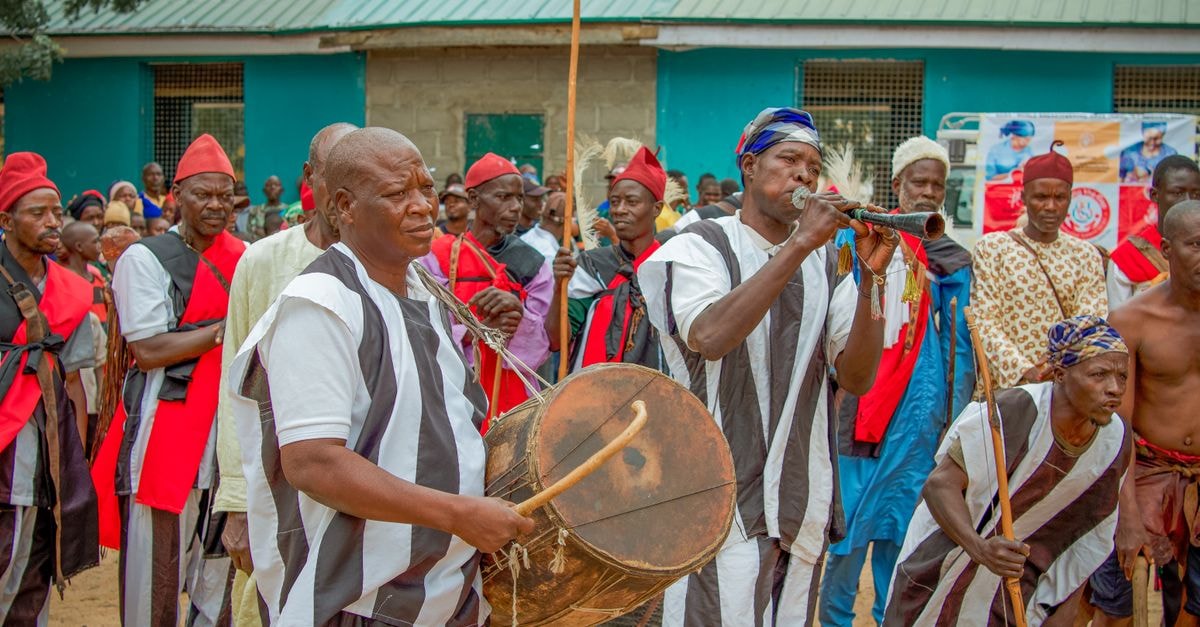 Ilesa travel guide: gateway rhythms of Osun State African musicians perform traditional music at a cultural event in Maiduguri, Nigeria, showcasing vibrant costumes.