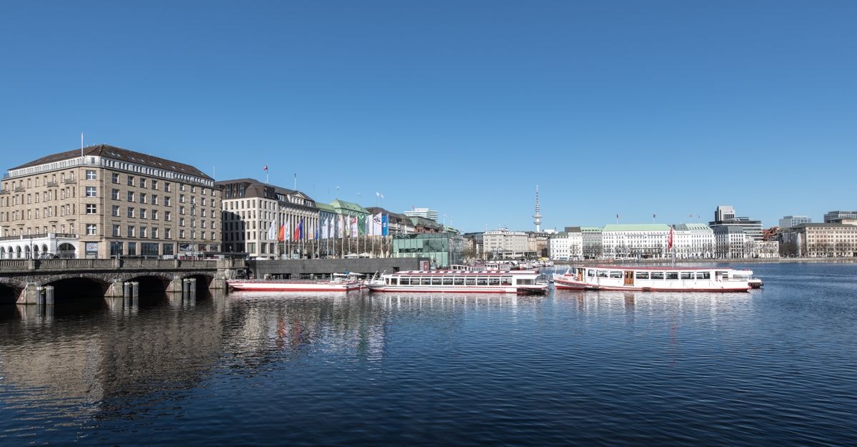 Idyllic view of Binnenalster with boats and city skyline in Hamburg.