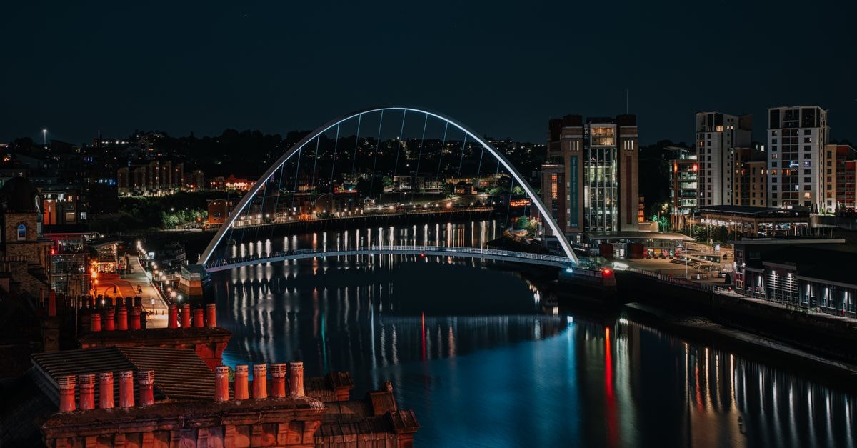 Newcastle upon Tyne: a slow, friendly travel guide Stunning nighttime cityscape of Newcastle's Millennium Bridge reflecting in the Tyne River.