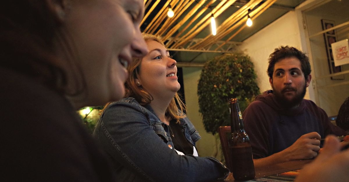 Albuquerque travel guide: getting around, seeing the sights, eating well Three adults enjoying a casual meal together in a warmly lit indoor setting.