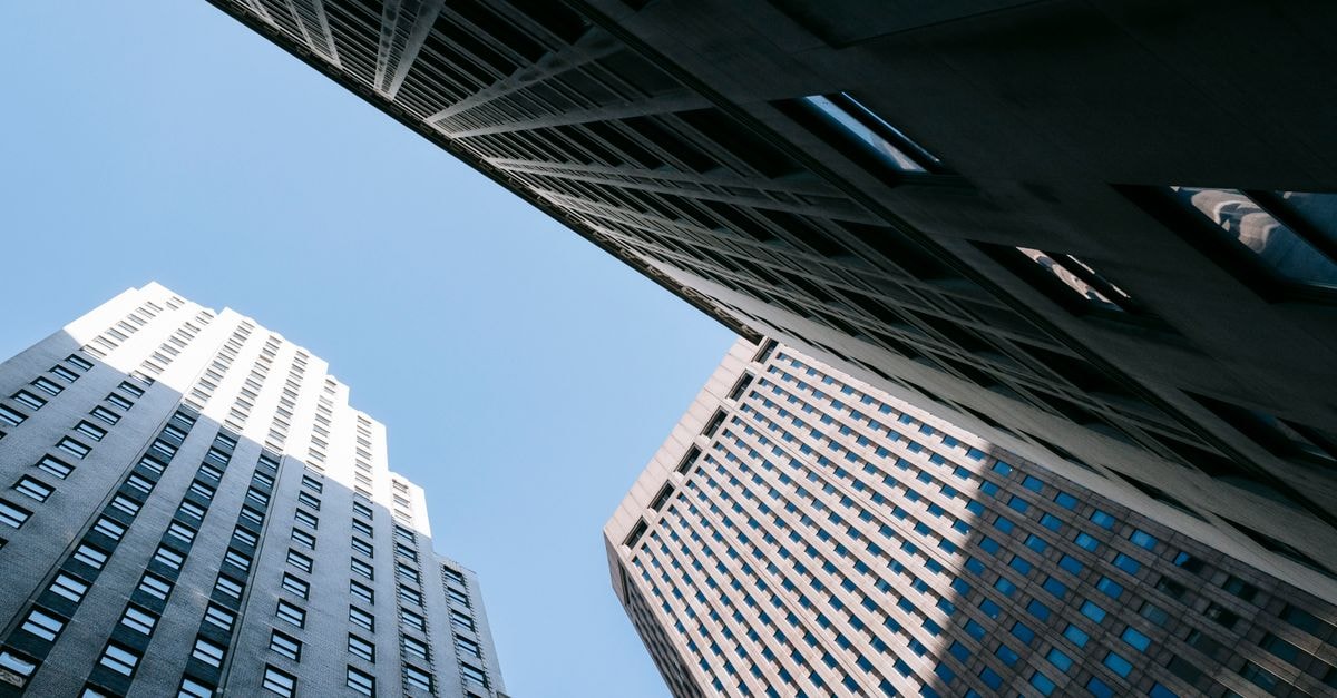 From below of contemporary high multistory office skyscrapers located in downtown against blue sky