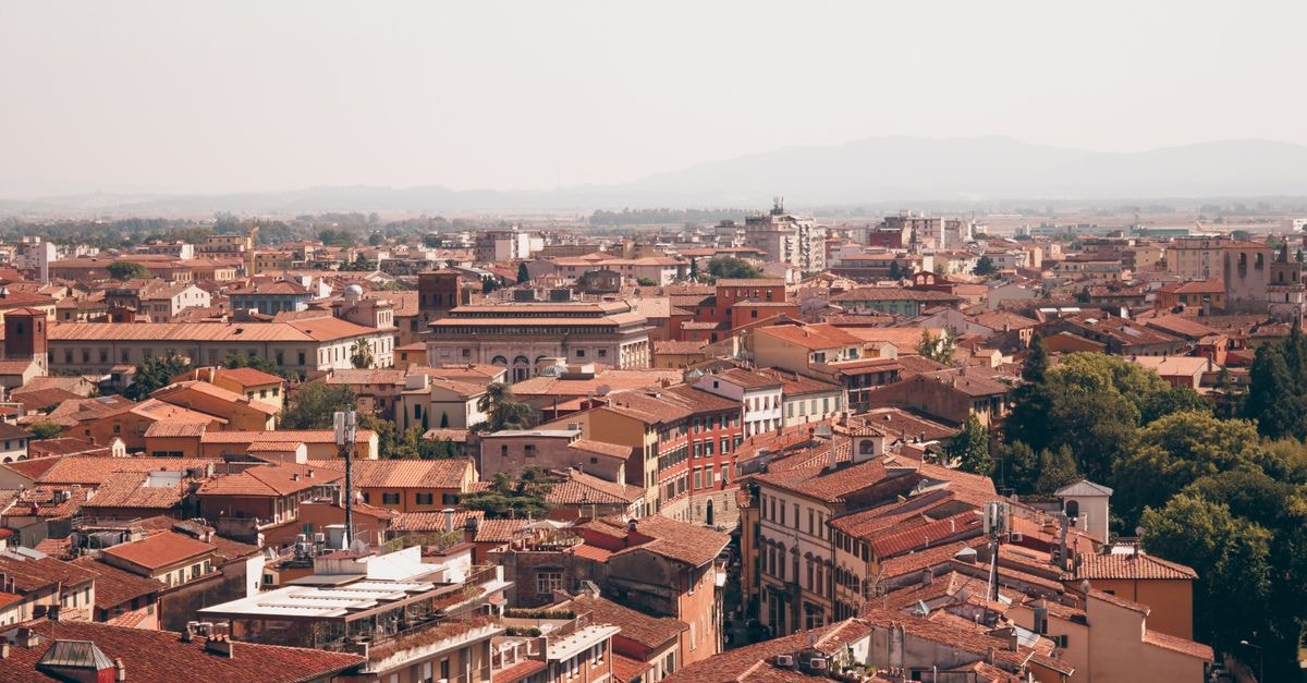 A breathtaking aerial view of Pisa, Italy showcasing its historic rooftops and urban layout.