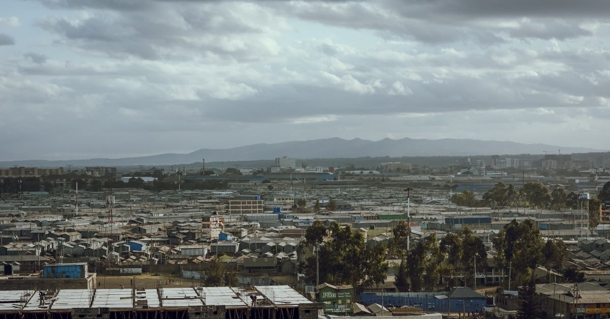 Aerial view of a cityscape with overcast clouds and construction in progress.