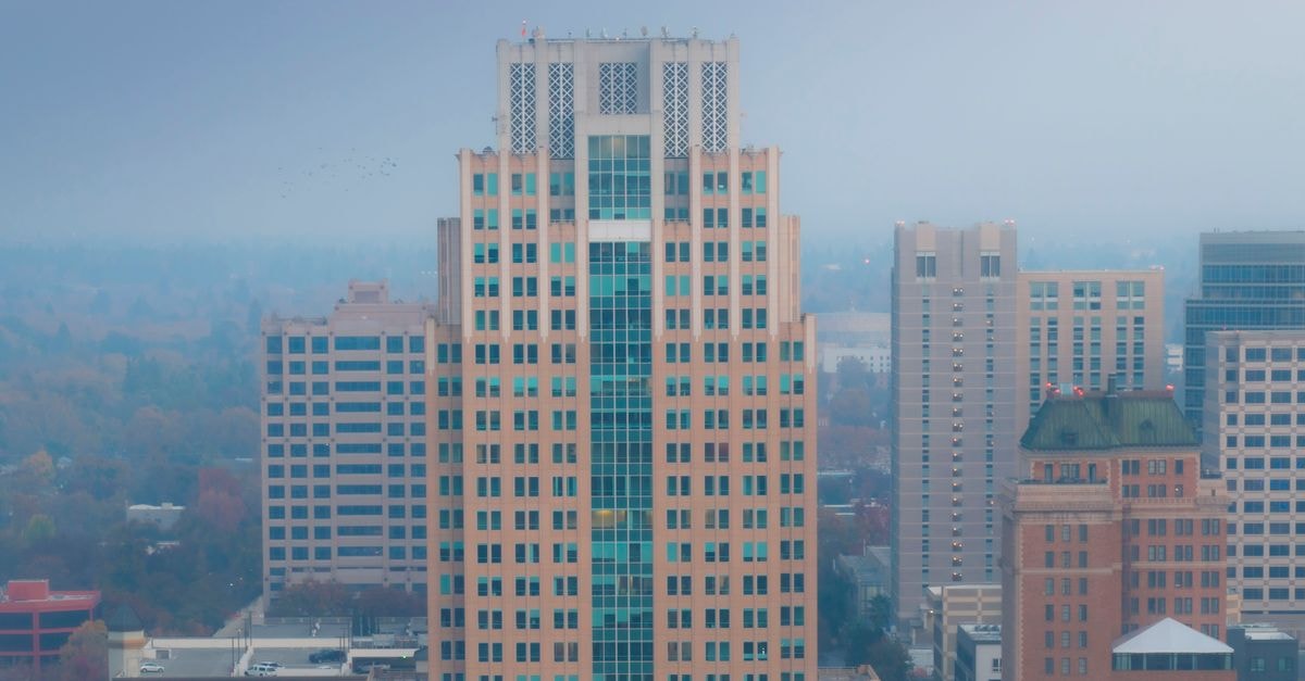 Aerial view of tall buildings in downtown Sacramento with foggy weather creating a serene cityscape.