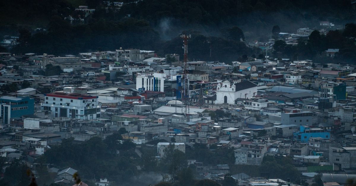 A stunning aerial view of Santa Cruz del Quiché, capturing its urban sprawl and surrounding landscape at dusk.