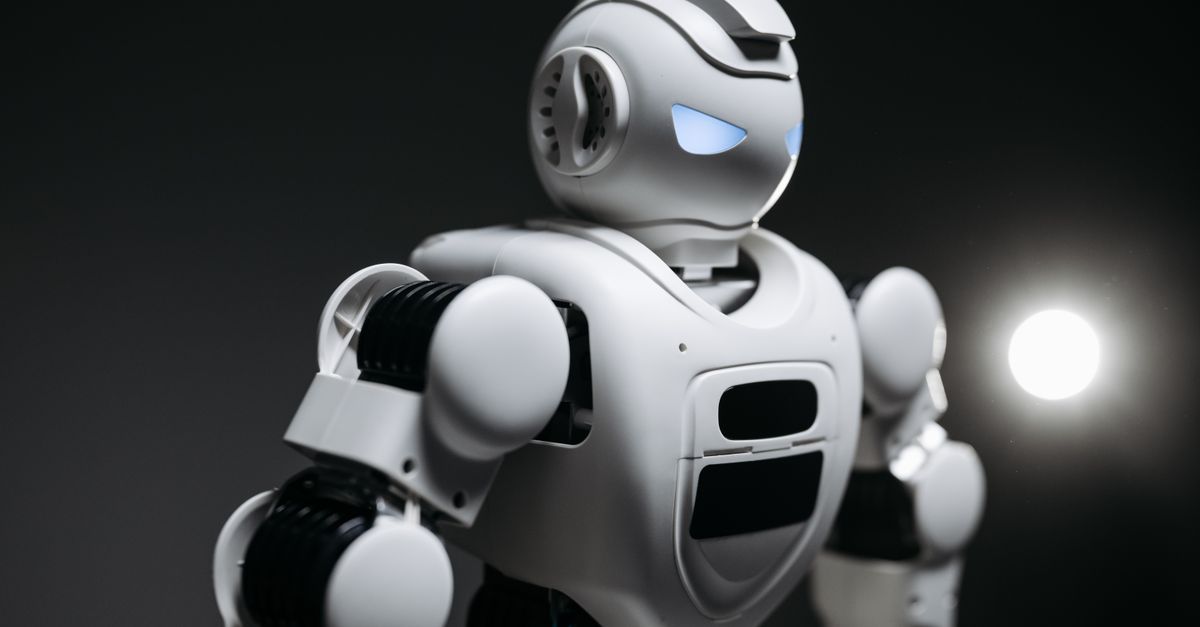High-detail close-up image of a white robot with glowing eyes in studio lighting. Modern tech innovation.