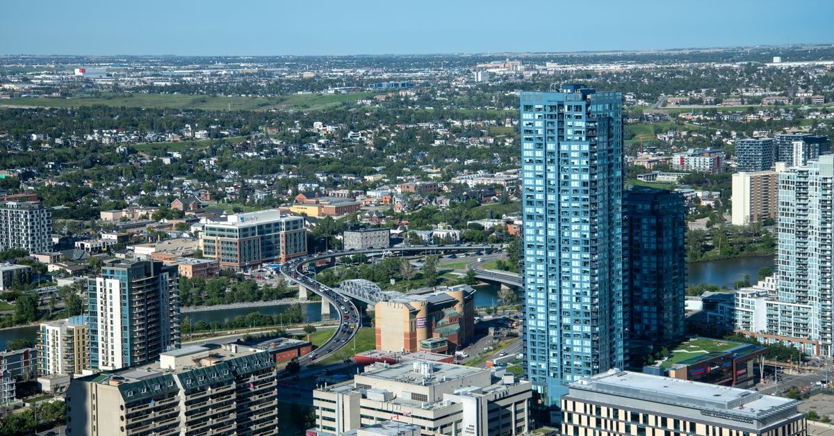 Comfort Inn Laval: Highway Access With Montreal-Style Convenience A vibrant cityscape with skyscrapers and a winding river under clear skies.