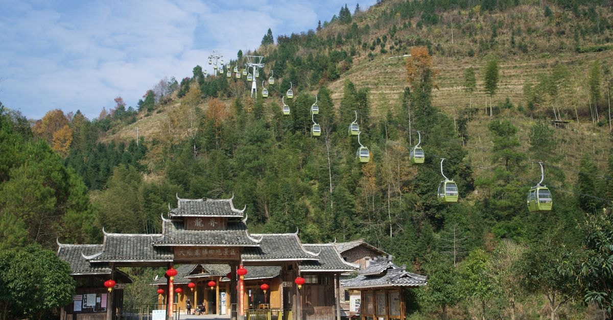Guigang, Guangxi: An Evergreen Travel Guide for Curious Explorers A traditional temple entrance with cable cars ascending a lush mountain landscape.