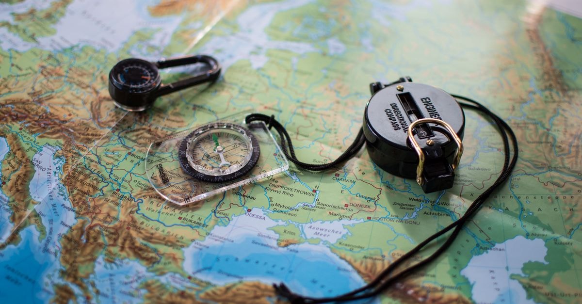Quthing Travel Guide: Planning Tips, Costs and Things to Do Flat lay of a European map with two compasses, symbolizing travel and exploration.