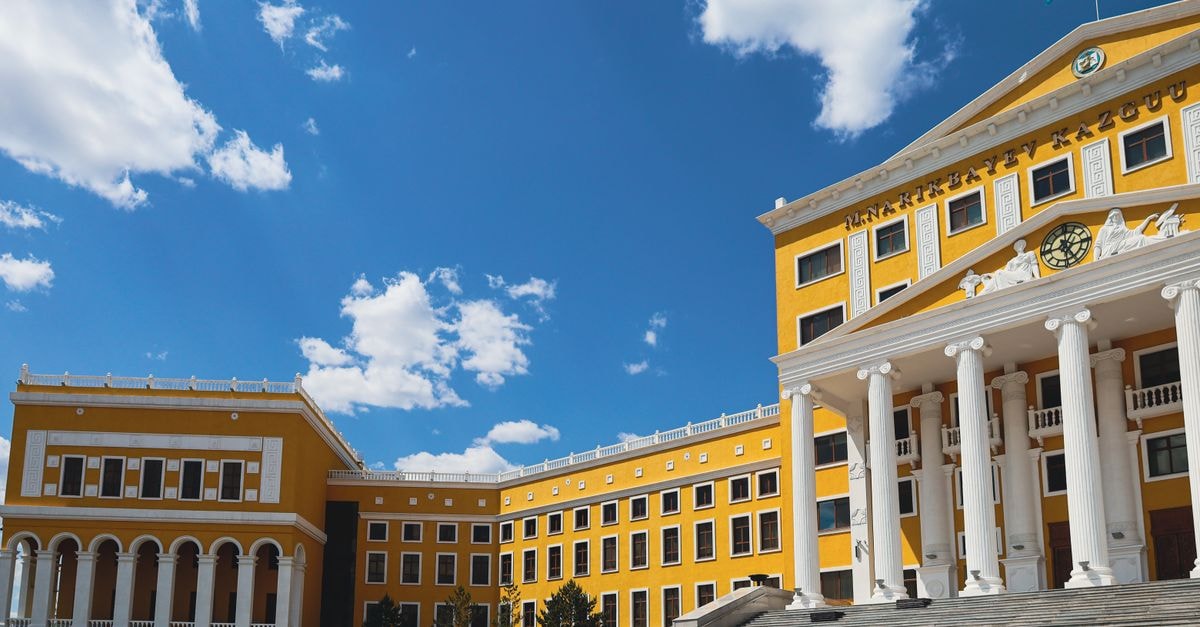 Pavlodar travel guide: Soviet-era landmarks and Kazakh cuisine Stunning architectural facade of a university in Kazakhstan against a vibrant blue sky.