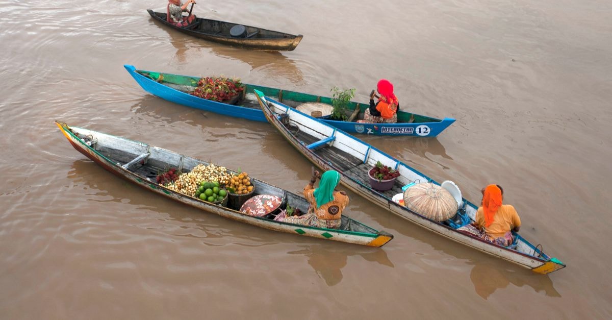Onitsha travel guide: markets, river views and Anambra rhythms Aerial view of vibrant floating market boats with produce on a calm river.
