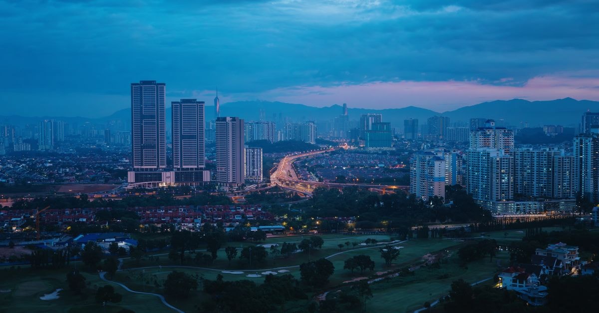 Aloft Kuala Lumpur Sentral: A Trendy Stay at KL Sentral A tranquil view of Kuala Lumpur's skyline during the blue hour with soft city lights.
