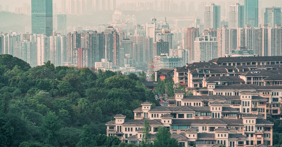 JinJiang Inn, Guiyang — Central Zhongshan East Road Address Urban skyline with densely packed skyscrapers and green foreground, depicting urban and natural elements.