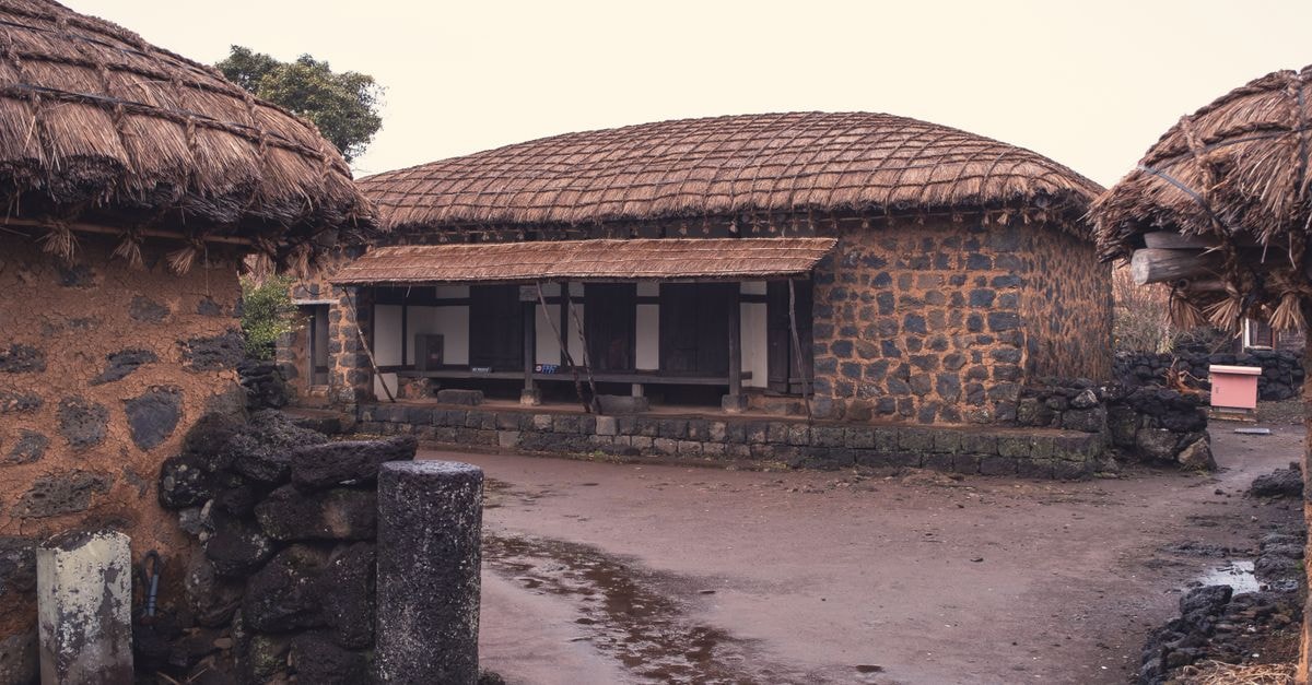 Hamhung Travel Guide — Things to Know Before You Go Capture of traditional stone houses with thatched roofs in a rural setting, exuding simplicity and historic charm.
