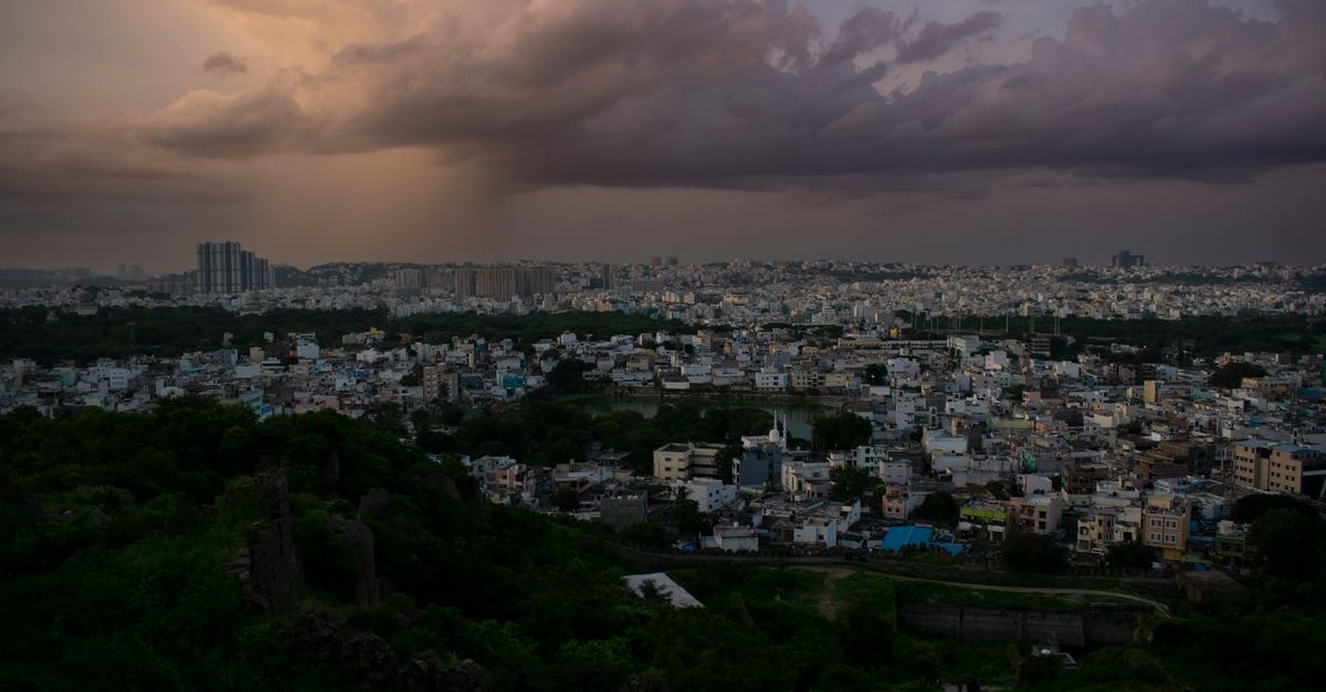 Sri Vaarahi Hotel, Warangal — A Green Stay on NH563, Gandhi Nagar A moody aerial view of a cityscape under a cloudy sky, capturing the urban expanse and dynamic light at twilight.