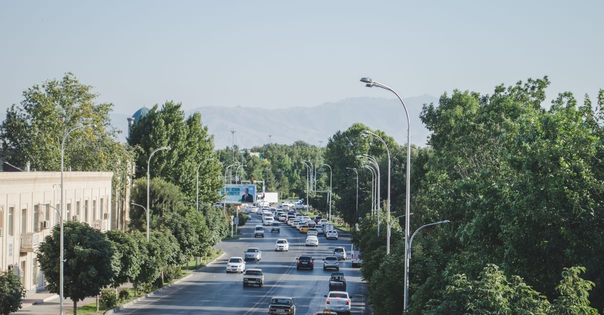 Khani Hotel in Duhok: Quiet Shakhke Quarter Stay Steps From the Centre A bustling urban street in Samarkand with traffic amidst lush greenery and mountain backdrop.