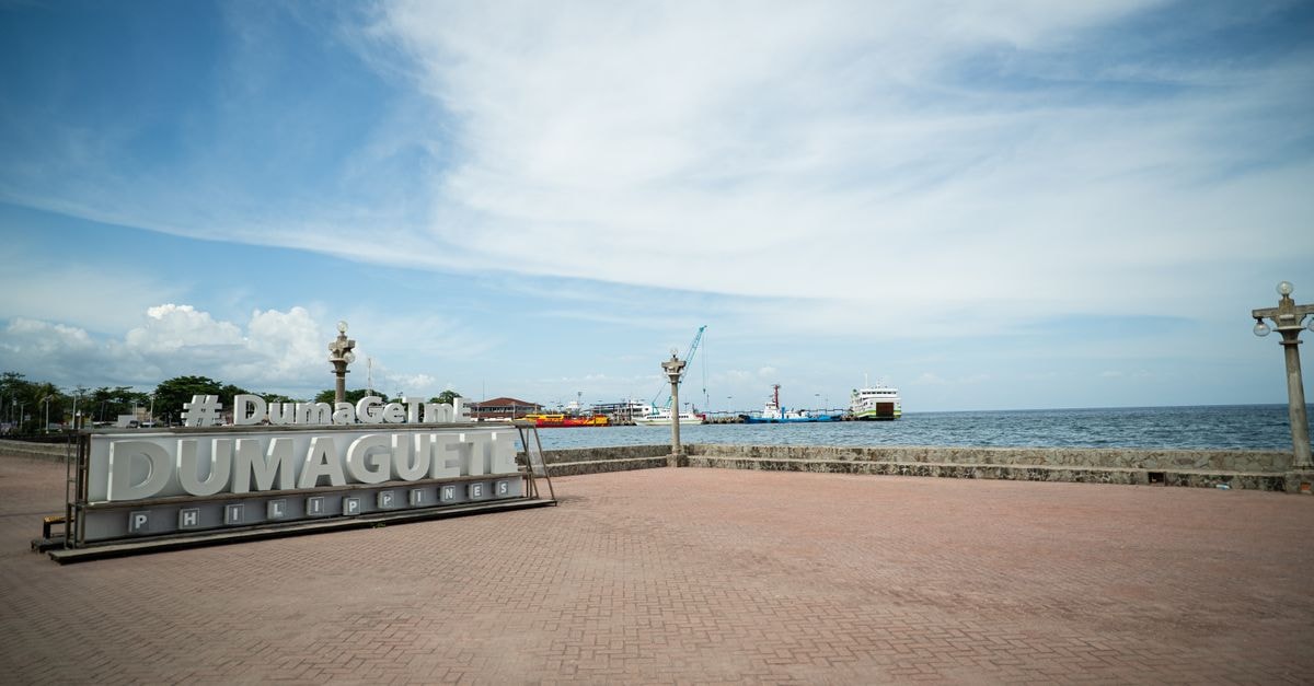 Zamboanga City Travel Guide: Planning Tips, Costs and Things to Do Scenic view of Dumaguete City harbor with iconic sign and ocean backdrop on a sunny day.
