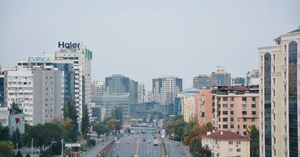 DoubleTree by Hilton Almaty: A Rooftop Retreat in the City Center Panoramic view of Almaty's urban skyline with modern buildings and city street.