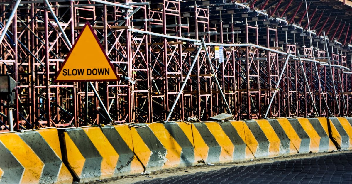 Prilep Travel Guide: A Quiet City Worth Slowing Down For Construction site with a 'Slow Down' sign amid scaffolding in Kuwait.