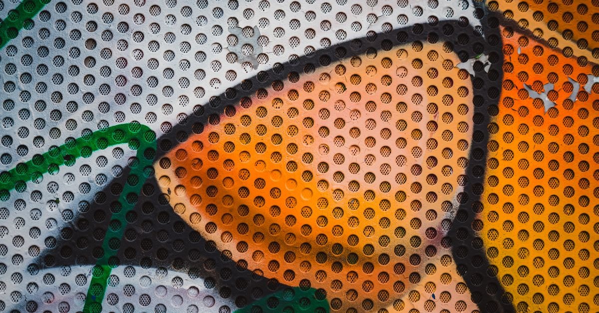 Close-up of colorful graffiti art on a perforated metal surface in Ostrava, Czechia.