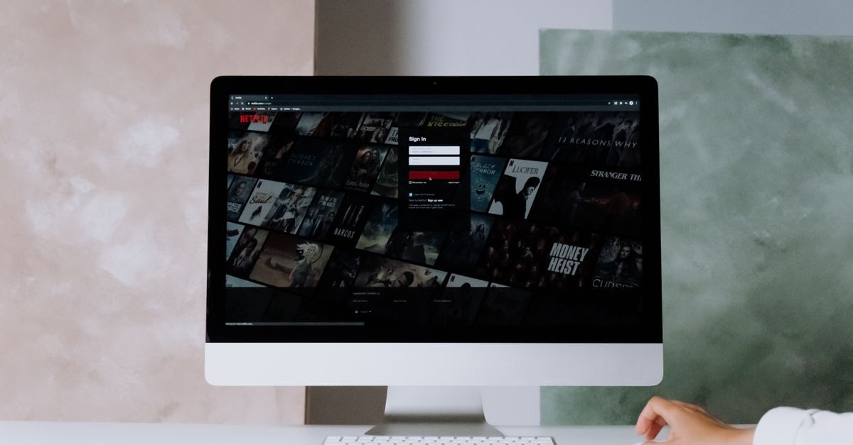 A modern desktop displays a streaming service interface, showcasing entertainment options in a minimalist office setting.
