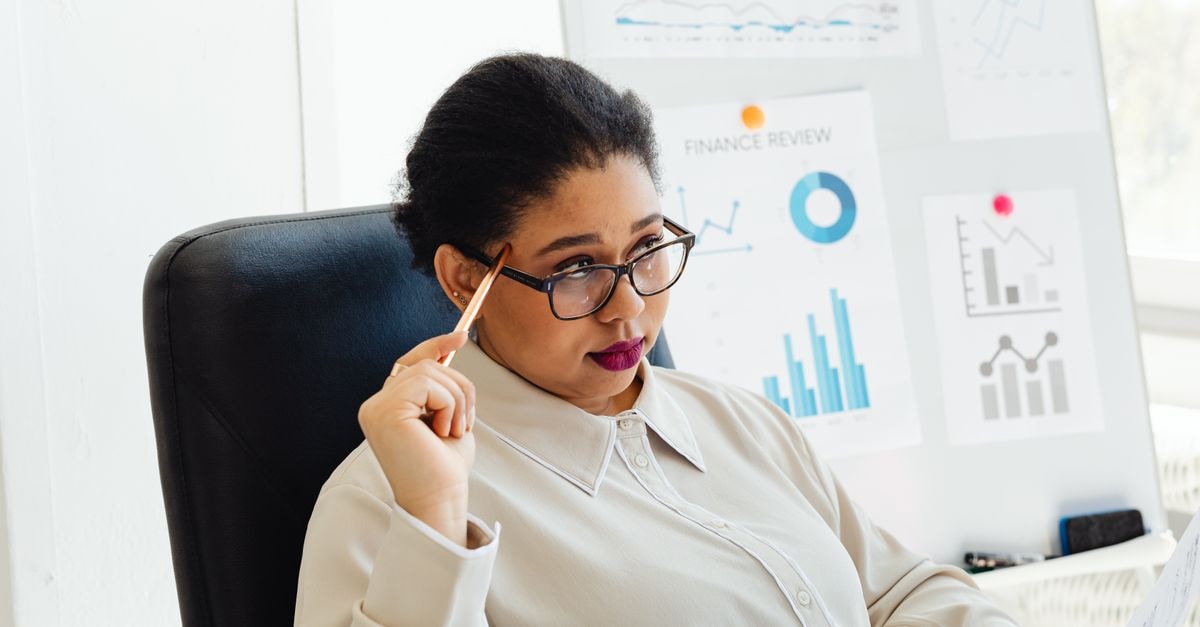 Beats 360 reviews position Apple's new over-ears as lighter, cheaper rival to AirPods Max Focused woman reviewing financial graphs during a presentation in a modern office setting.